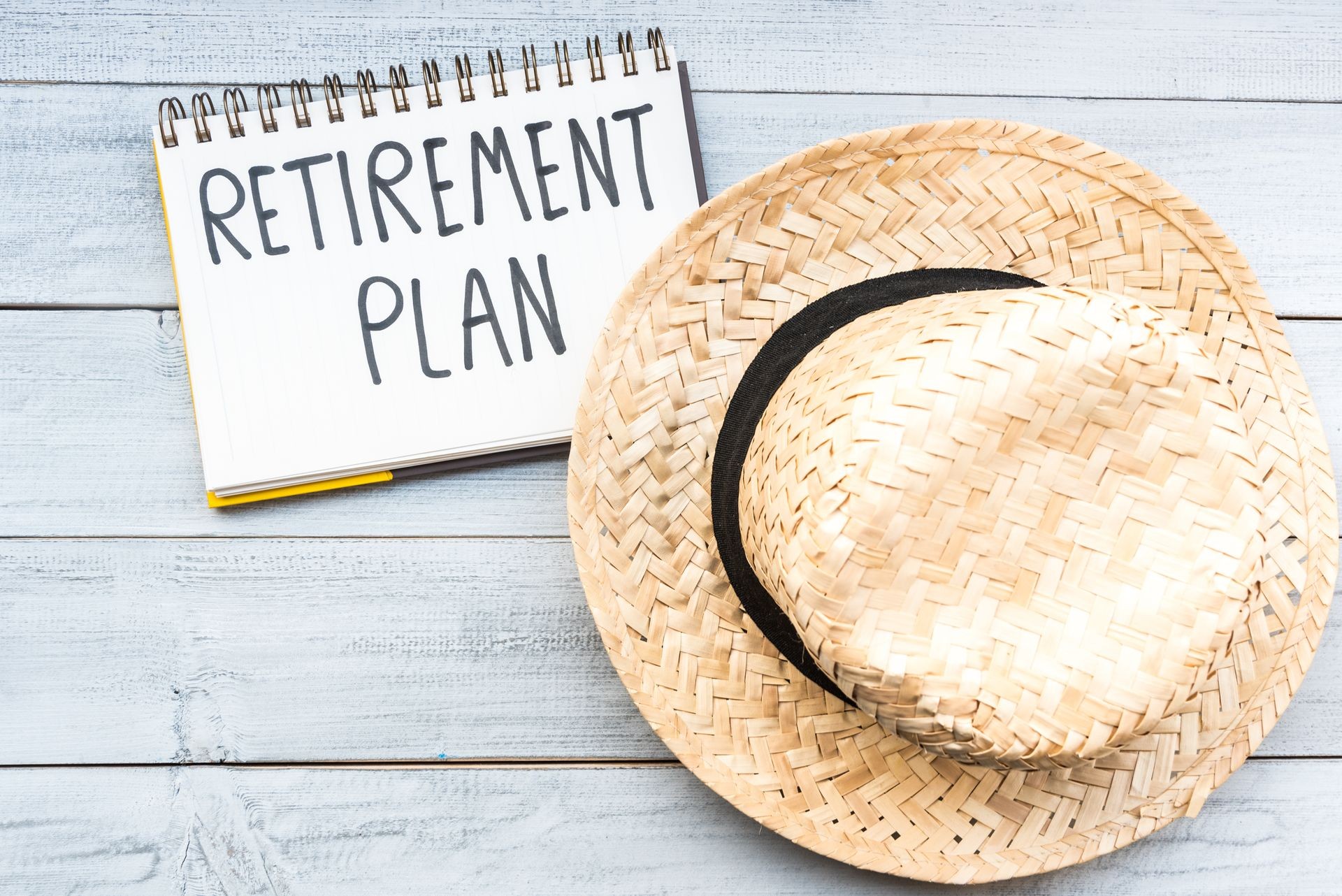 Retirement plan hand written in a note, concept of starting senior investment pension retirement life with hat on white wooden background. Happy vacation retire. Retirement plan hand written in a note, concept of starting senior investment pension retirement life with hat on white wooden background. Happy vacation retire.